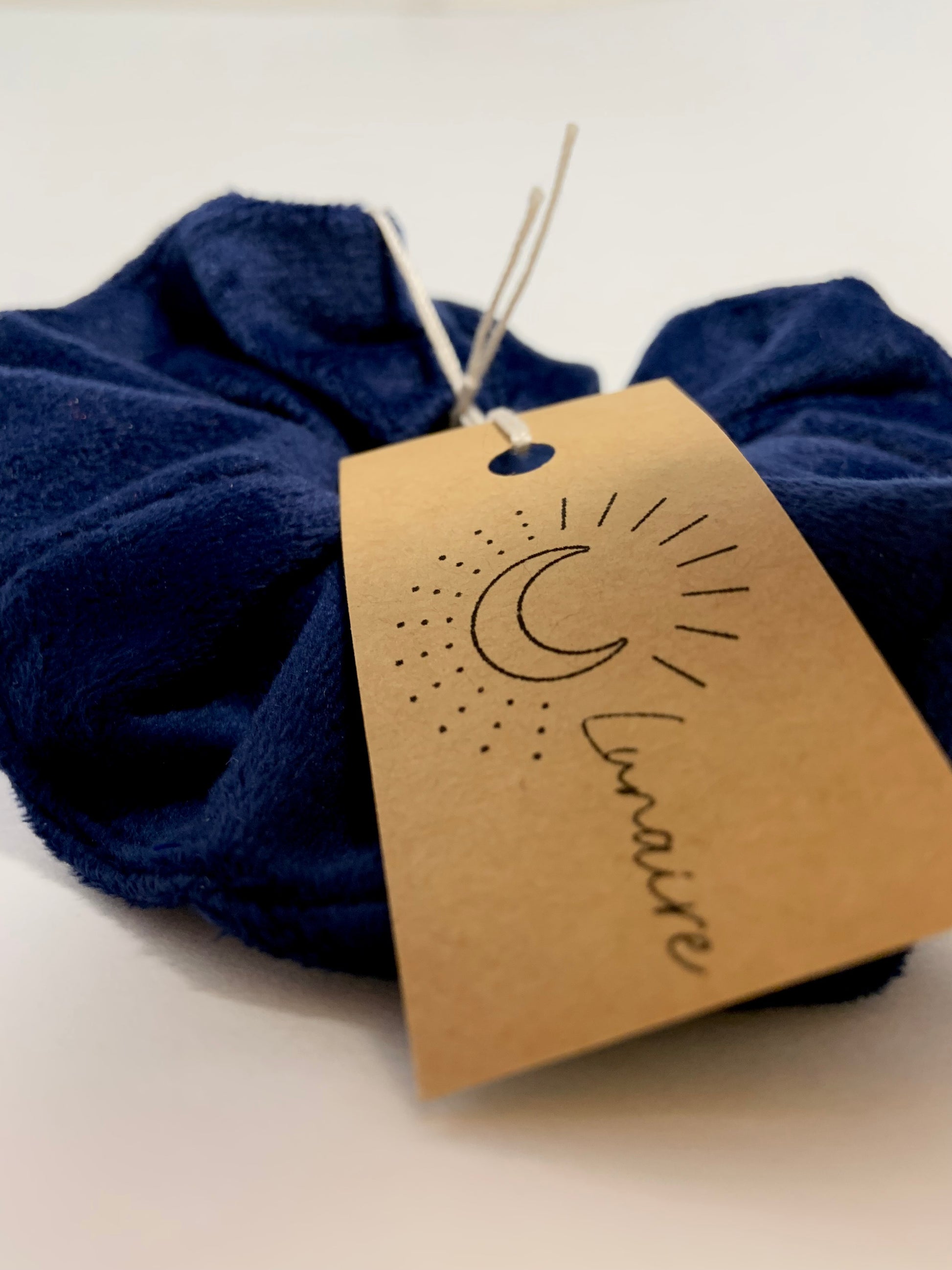 Chou bleu velours sur arrière-plan blanc. Focus sur la texture douce et sur l'étiquette Lunaire.