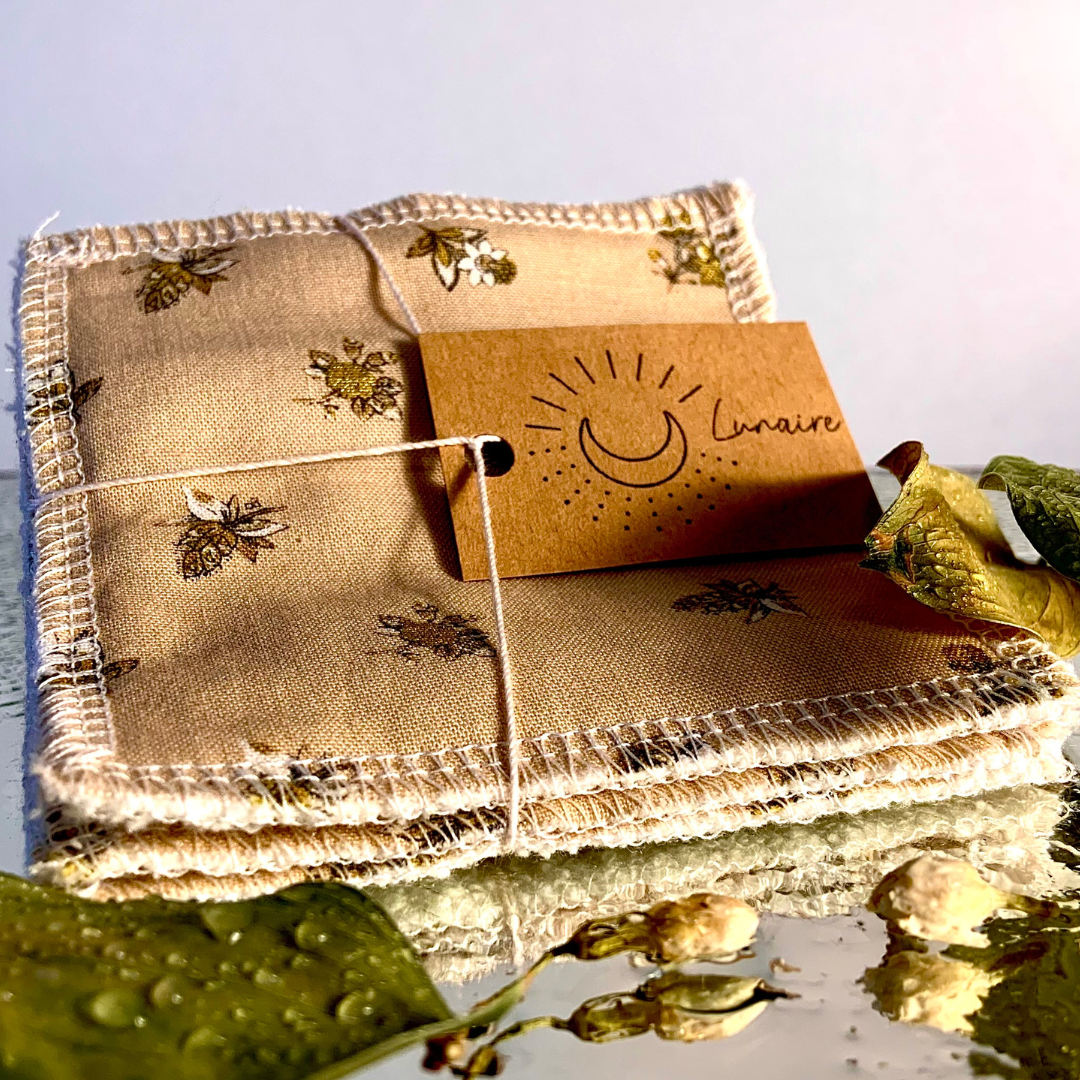 Paquet de trois tampons démaquillants Lunaire dans un décors de feuille et de bourgeons trempés de rosé. Le tissus est beige avec des fleurs dorées. 